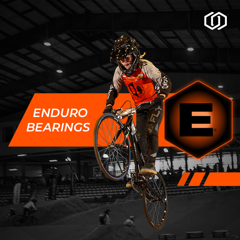 Biker performing a trick on a bike with Enduro Bearings branding in the background.